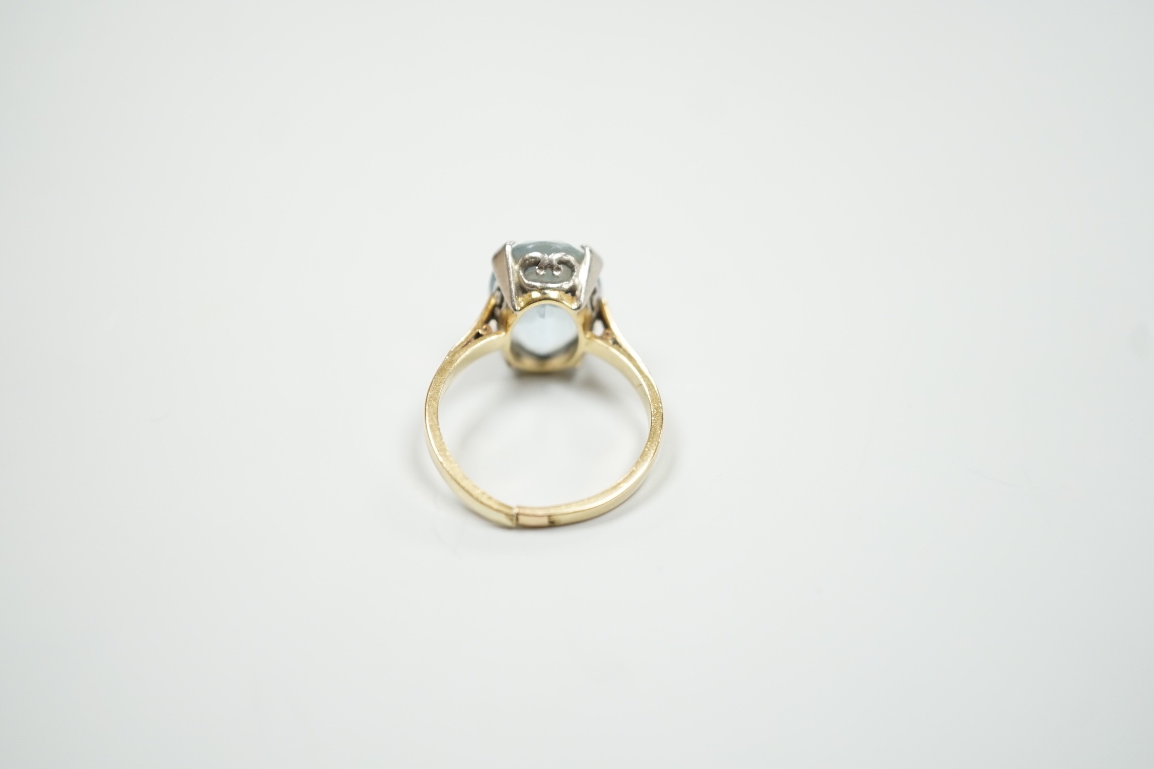 An 18ct and oval cut aquamarine set ring, (shank cut), size P, gross weight 5.3 grams.